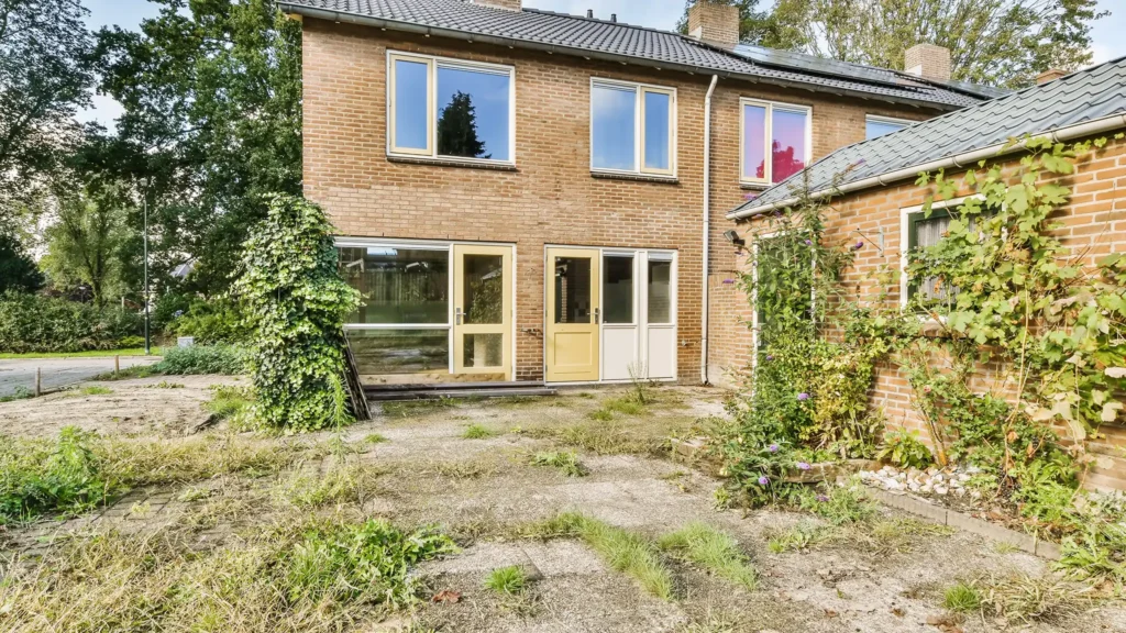 A Chowns Agricultural Services An urban house with overgrown trees and bushes in Warwickshire.
