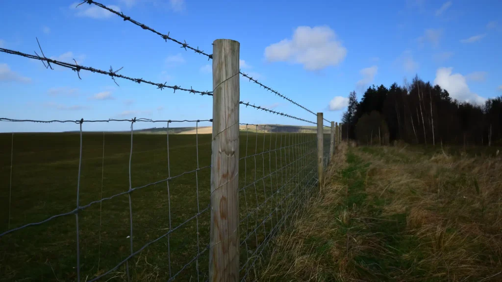 A Chowns Agricultural Services A farming field in Alcester, Worcestershire, with a barbed wire fence running through it.