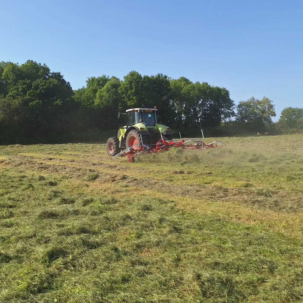 A Chowns Agricultural Services A tractor is working on a field of grass in Warwickshire.