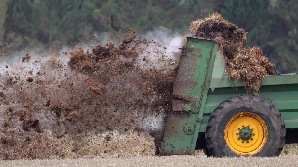 A Chowns Agricultural Services Worcestershire farming services involve a tractor dumping hay into a field as part of their agricultural services.