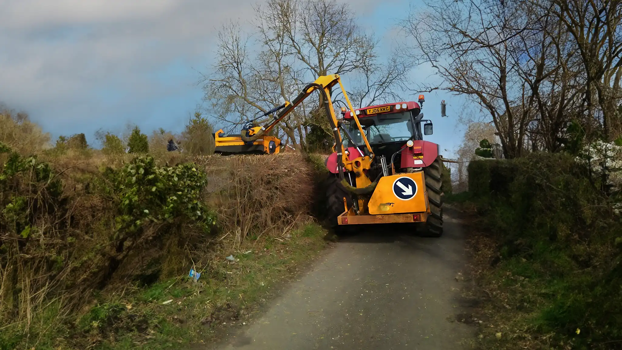 A Chowns Agricultural Services A tractor is hedge cutting down a country road in Worcestershire.